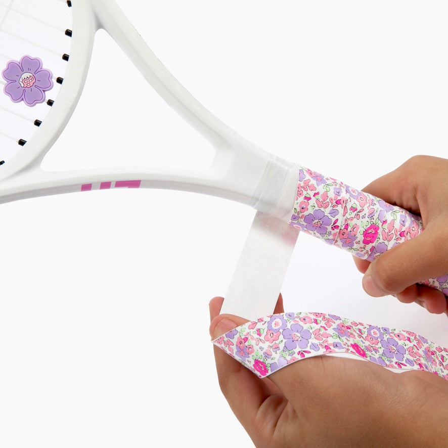 Hand holding racket adorned with The Anneliese Collection Matching Tennis Overgrip and Dampener - Purple