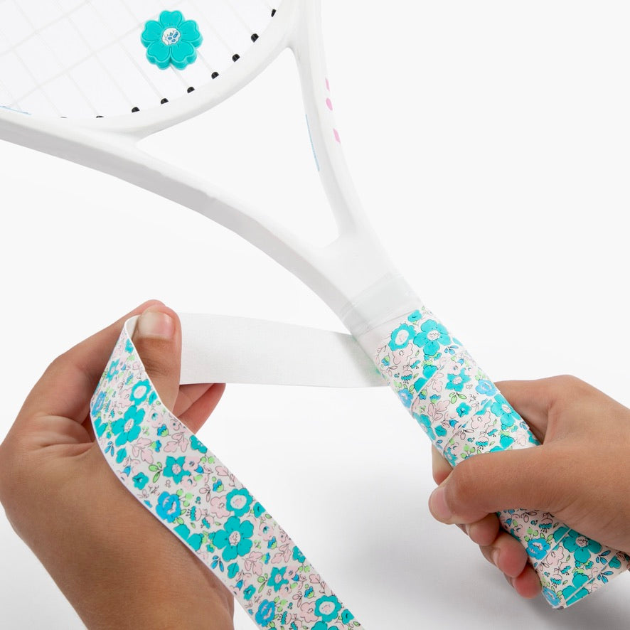 Hand holding racket adorned with The Anneliese Collection Matching Tennis Overgrip and Dampener - Turquoise