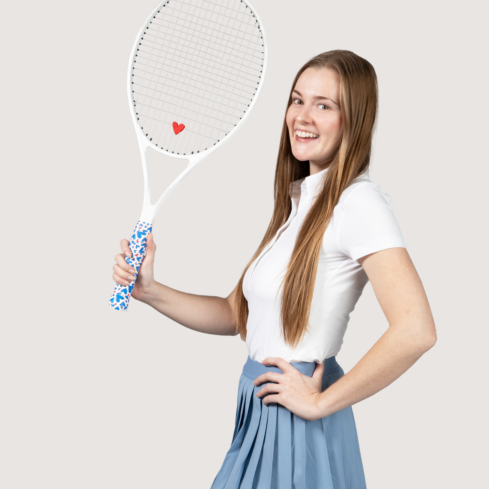 woman holding tennis racket with heart shaped tennis grip and matching dampener