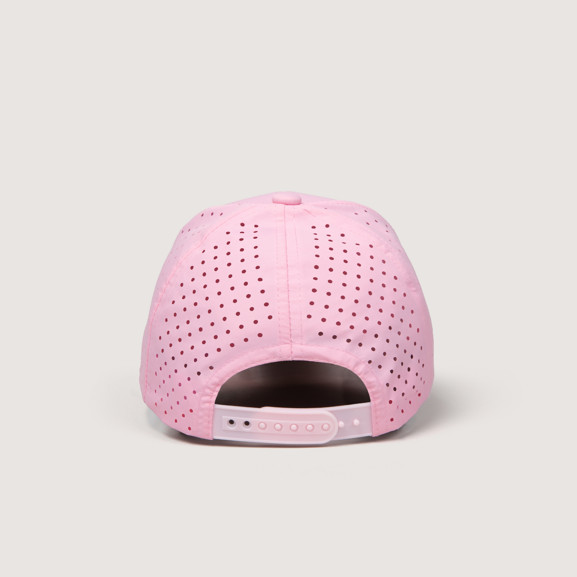 Pink cap with perforated design on a light gray background