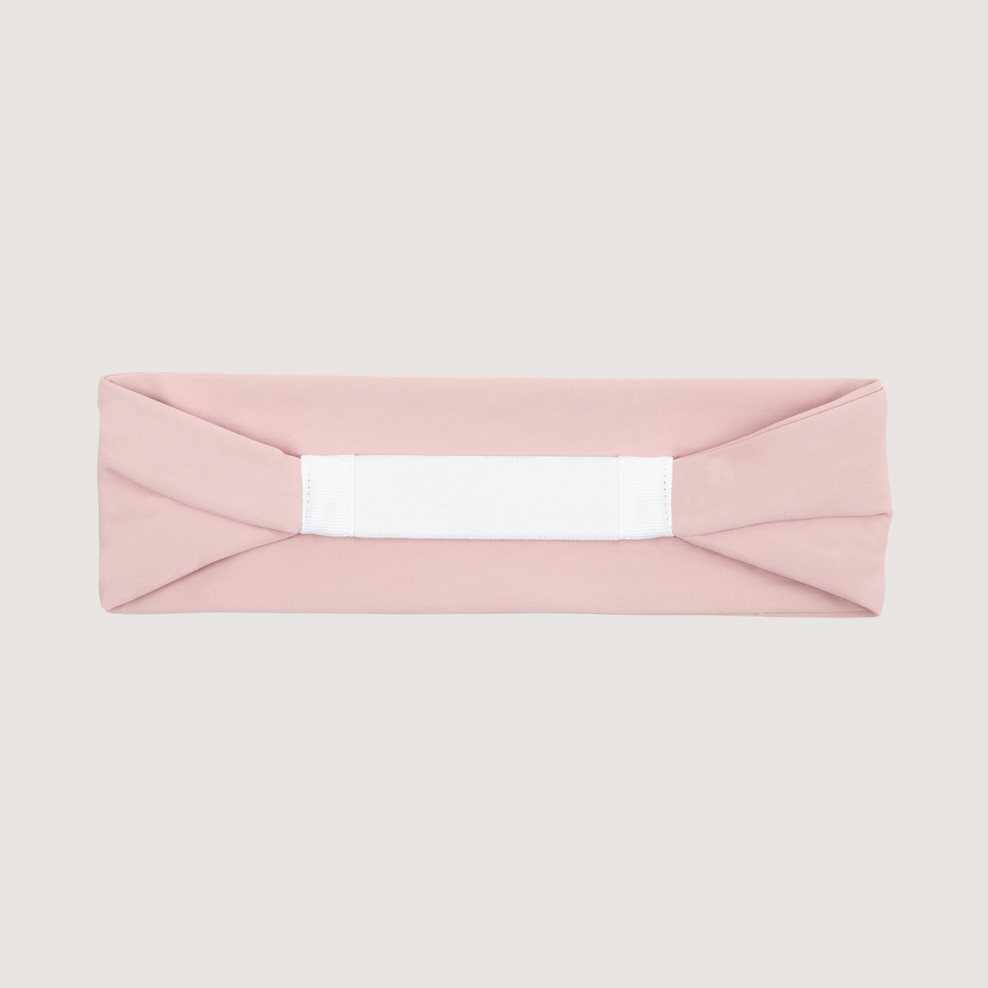 Pink headband with a white elastic band on a light gray background
